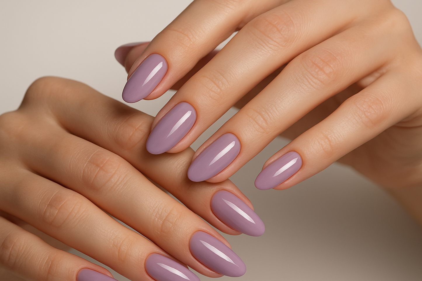 Close-up of hands with lavender nail polish on a neutral background